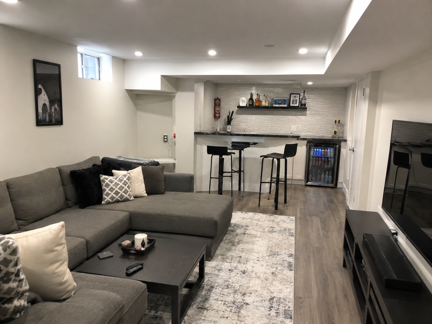 Finished basement family room with wet bar, pool table, and mounted TV